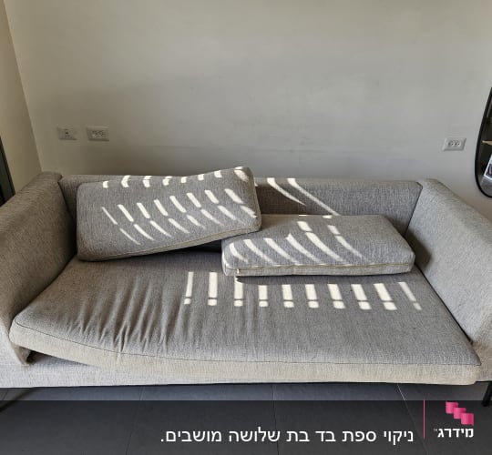 ספה אפורה עם כריות מונחות עליה